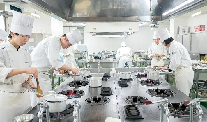 厨房で料理をする生徒たち