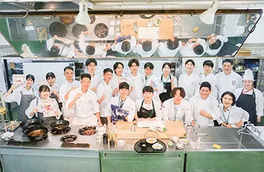 ウェイターとして料理を運ぶ男子生徒 写真